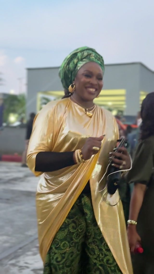 Netima wearing her original gold and green occasionwear creation at a wedding